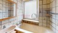 Badezimmer mit Fenster und Wanne